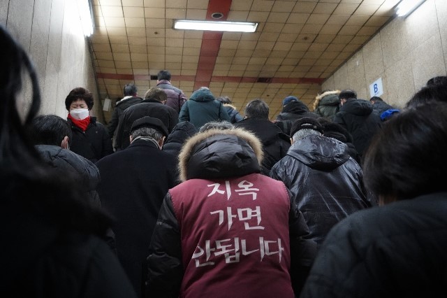 韓國地鐵內，一名中年大叔穿著「勿入地獄」的背心特別醒目。