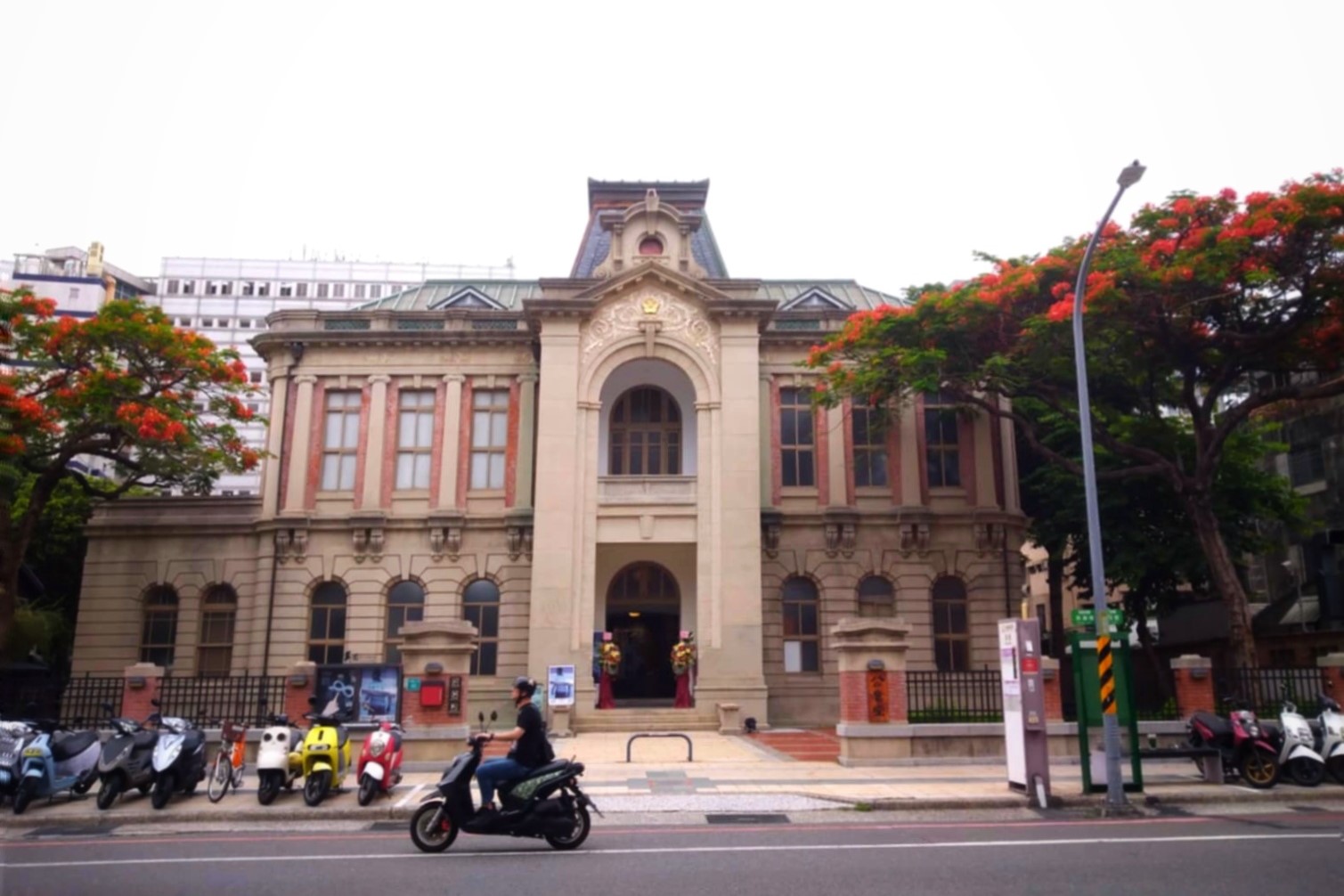 如果你是不會騎機車，但是很想開始台南獨旅的I型人，那就避開假日吧！圖為鳳凰花開的台南公會堂。